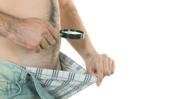 un homme regarde à l'intérieur de ses sous-vêtements et pense à agrandir son pénis avec du soda